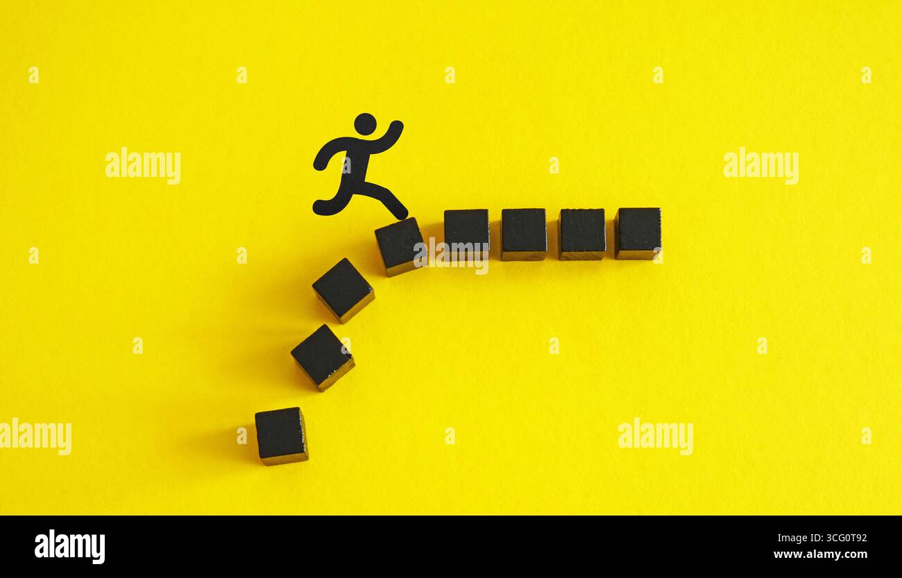 Person jumping over obstacles made of blocks. Personal growth. Stock Photo