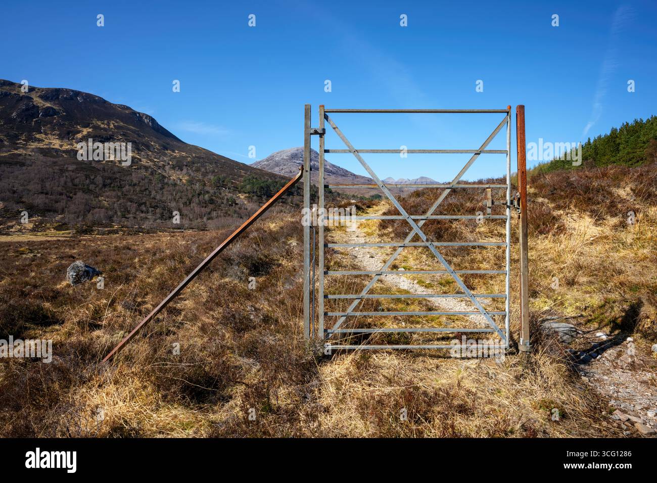 An old and redundant metal gate standing alone in the Scottish mountains, where no fencing remains any longer. Stock Photo