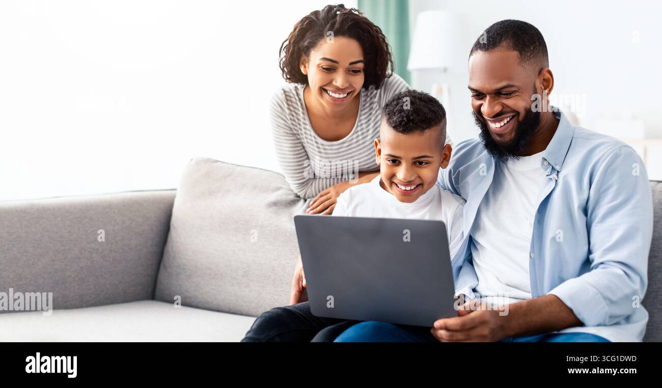 Happy african american family using laptop in living room Stock Photo ...