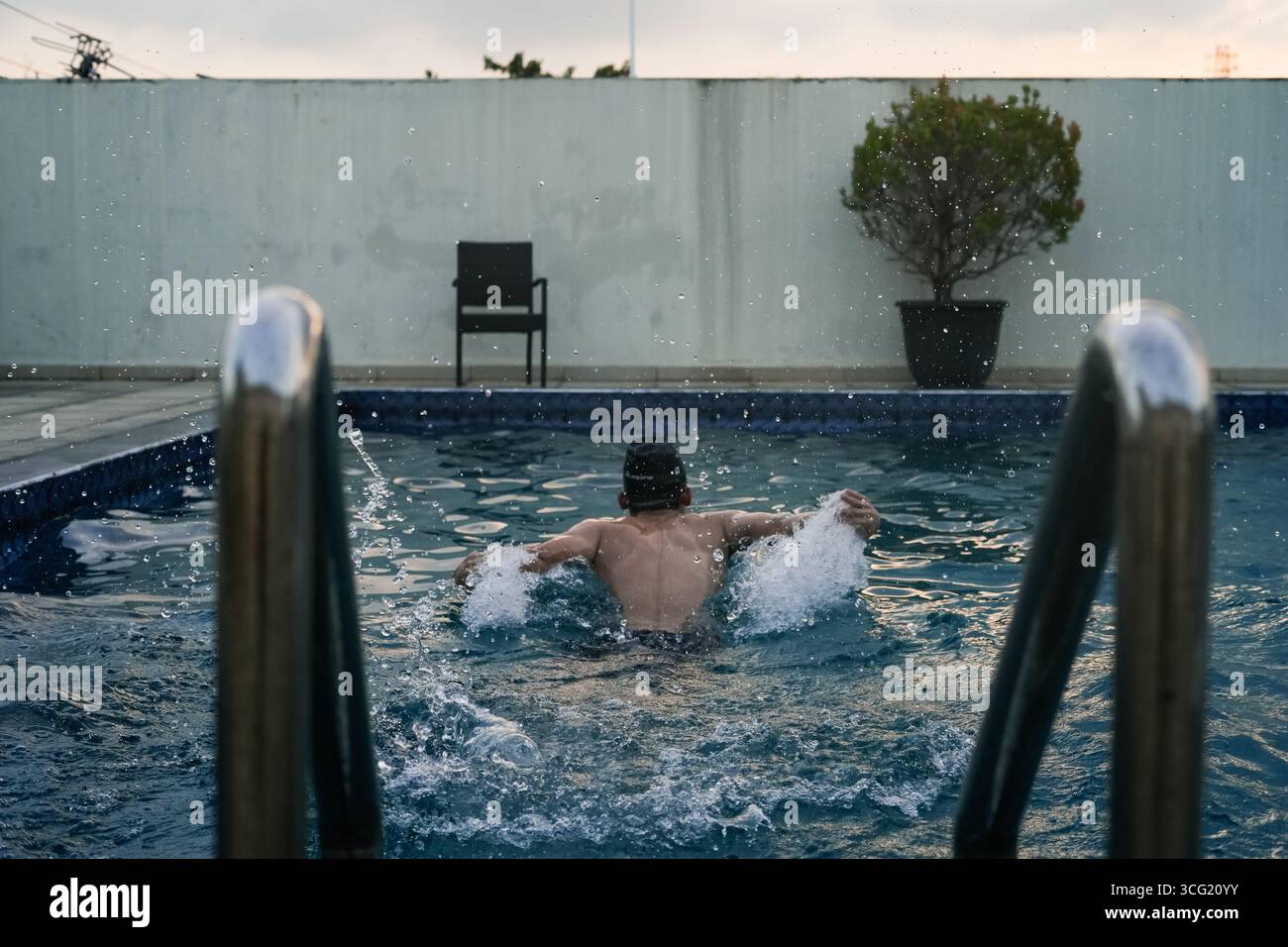 focused athlete swimming front butterfly style in a sparkling pool ...