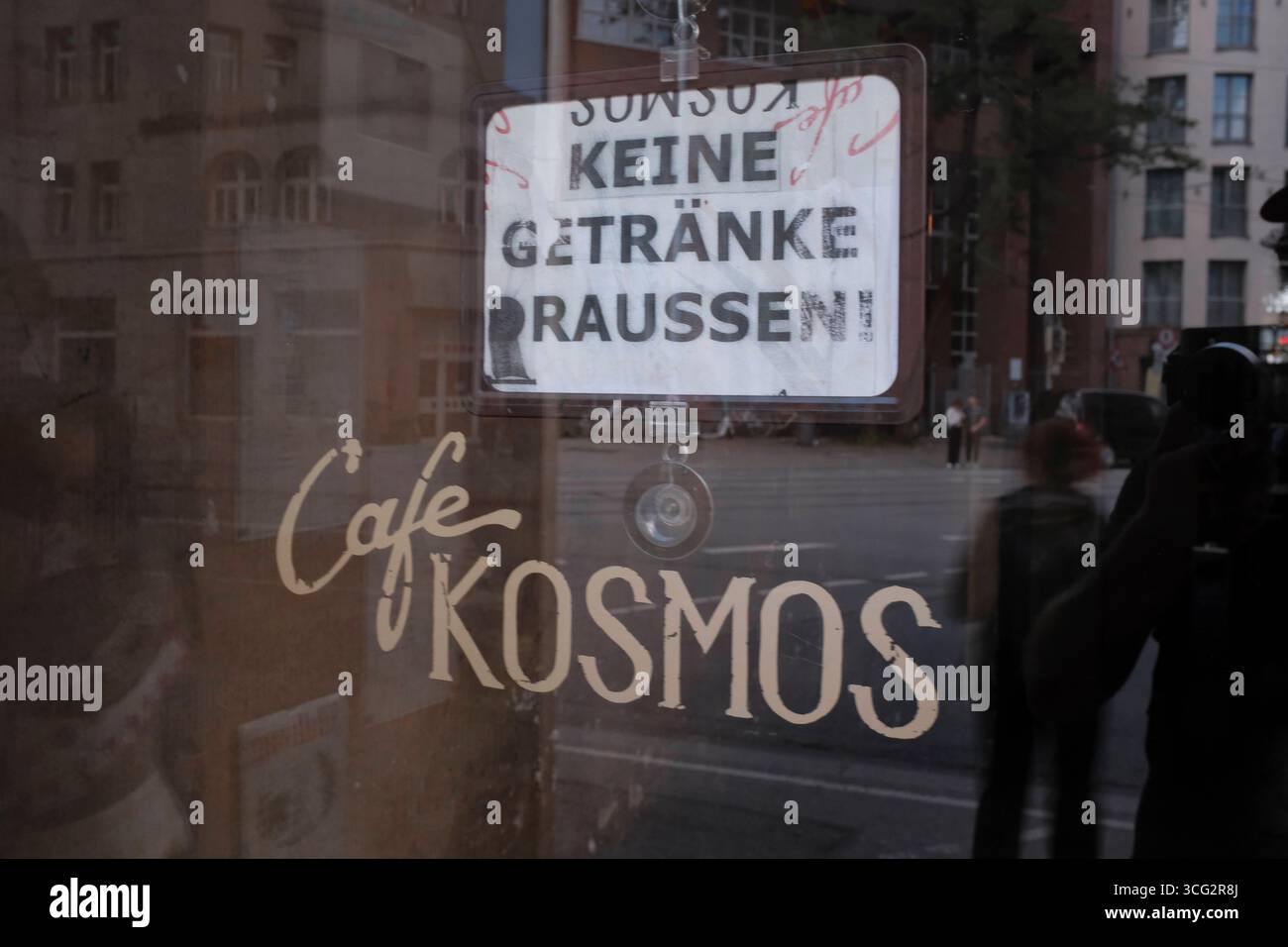 Keine Getränke draussen Keine Getränke draussen. Schild hinter Eingangstür des Cafe Kosmos *** No drinks outside No drinks outside sign behind the ent Stock Photo