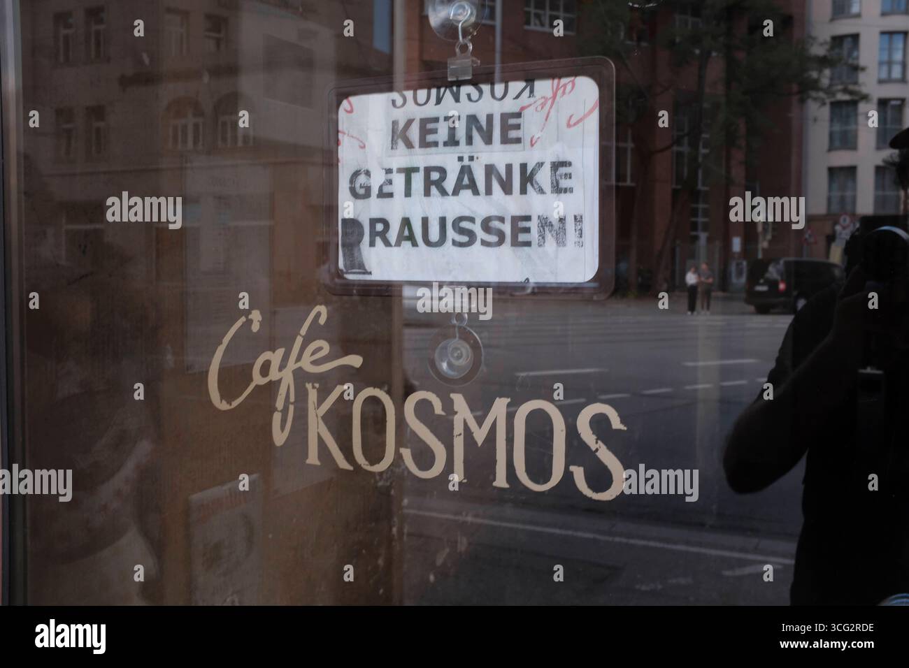 Keine Getränke draussen Keine Getränke draussen. Schild hinter Eingangstür des Cafe Kosmos *** No drinks outside No drinks outside sign behind the ent Stock Photo