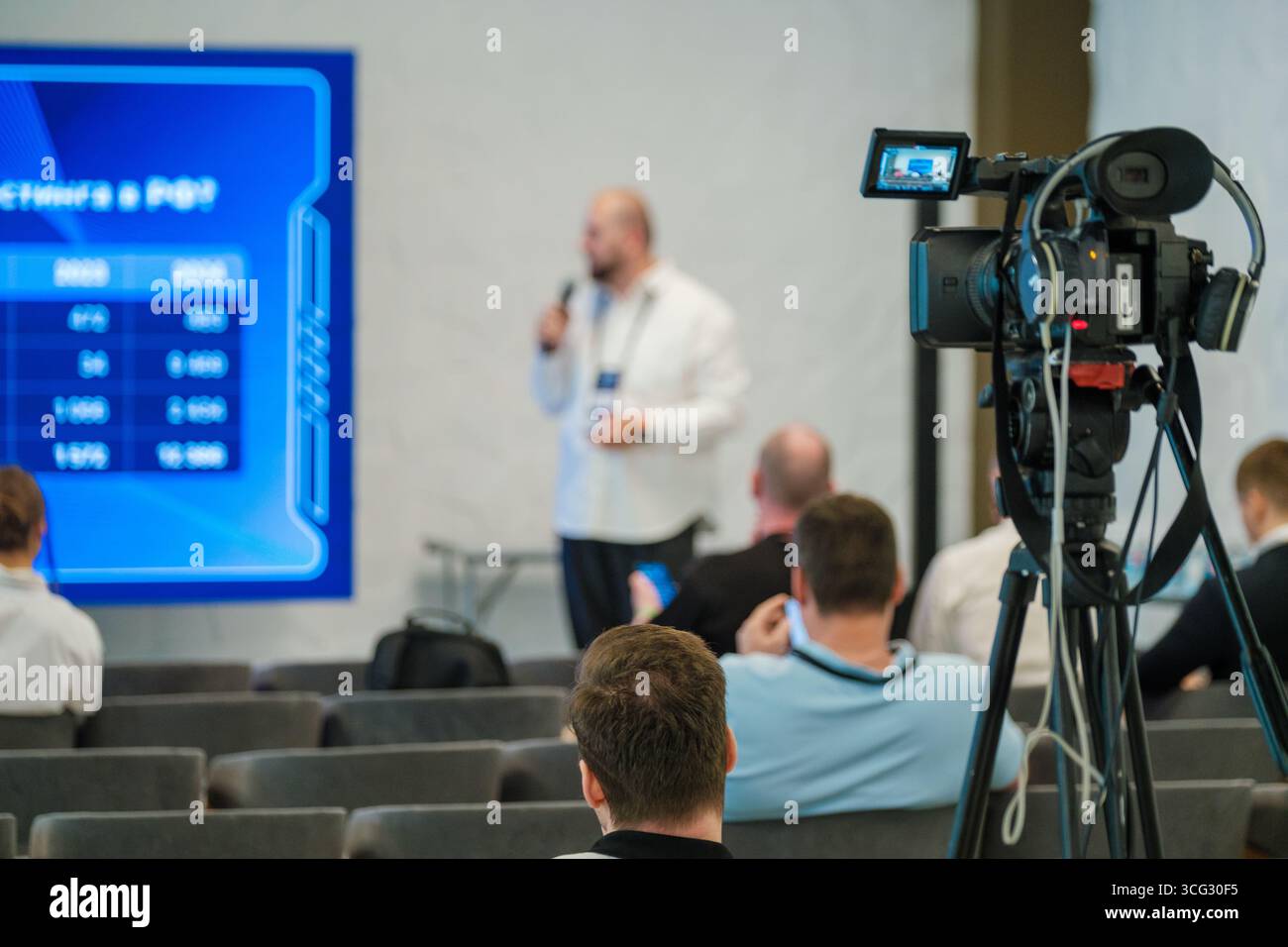 Person speaking at business event recorded with video camera. Audience ...