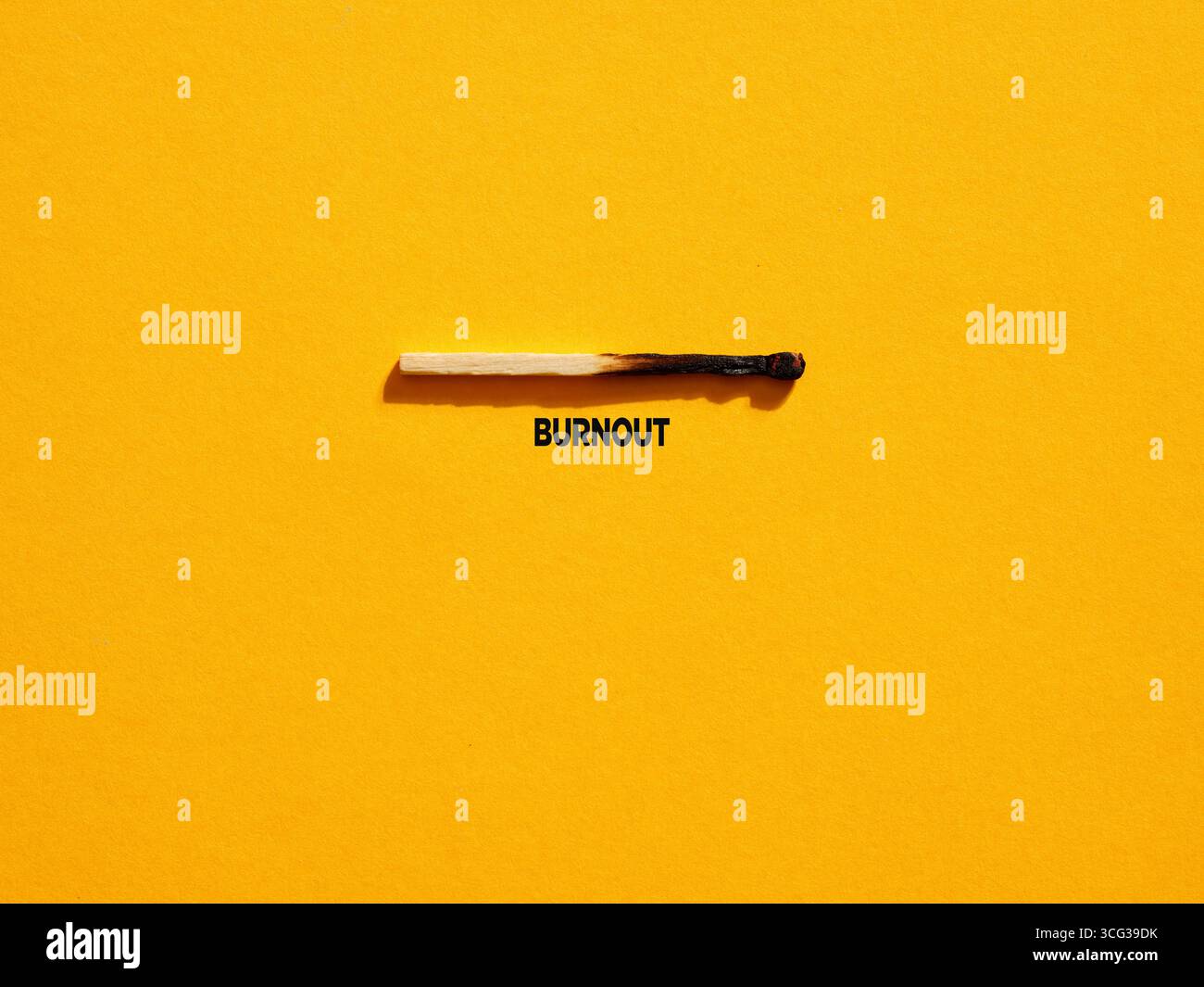 Burnt match on a yellow background with the word burnout written below representing the concept of professional burnout syndrome Stock Photo