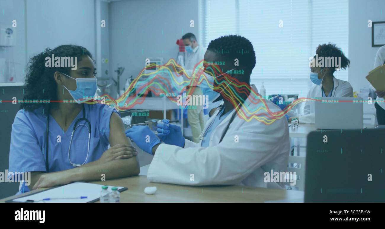 Nurse in blue scrubs receiving vaccine injection from doctor in clinic ...