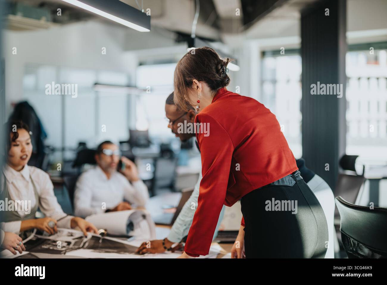 Diverse business team collaborates on project in modern office setting Stock Photo