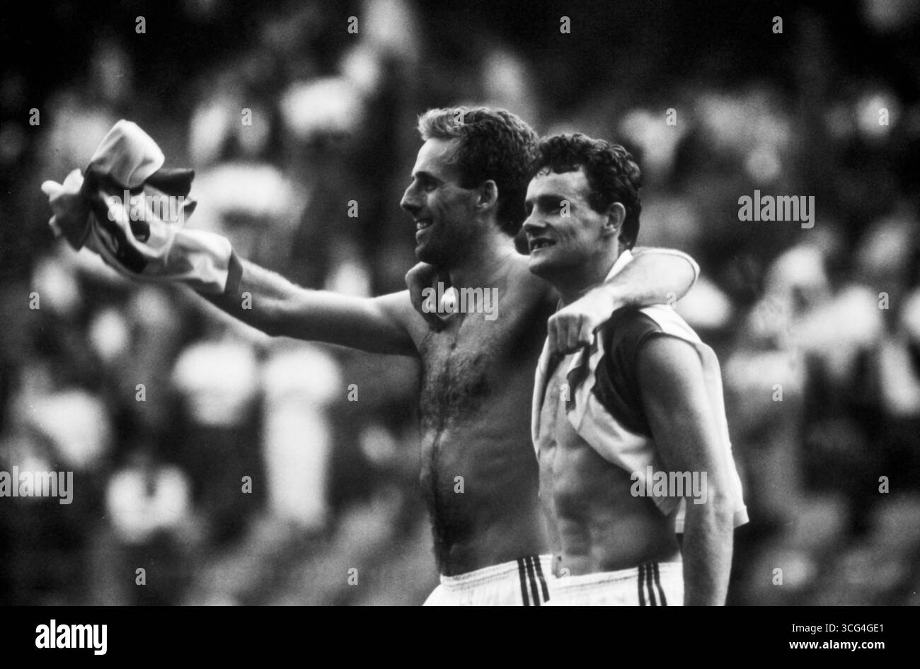 Mick McCarthy (li.) und Kevin Moran (Zahnlücke) jubeln Arm in Arm nach dem dramatischen Achtelfinal-Sieg im Elfmeterschießen gegen Rumänien bei der Fußball-Weltmeisterschaft 1990 in Italien. Stock Photo