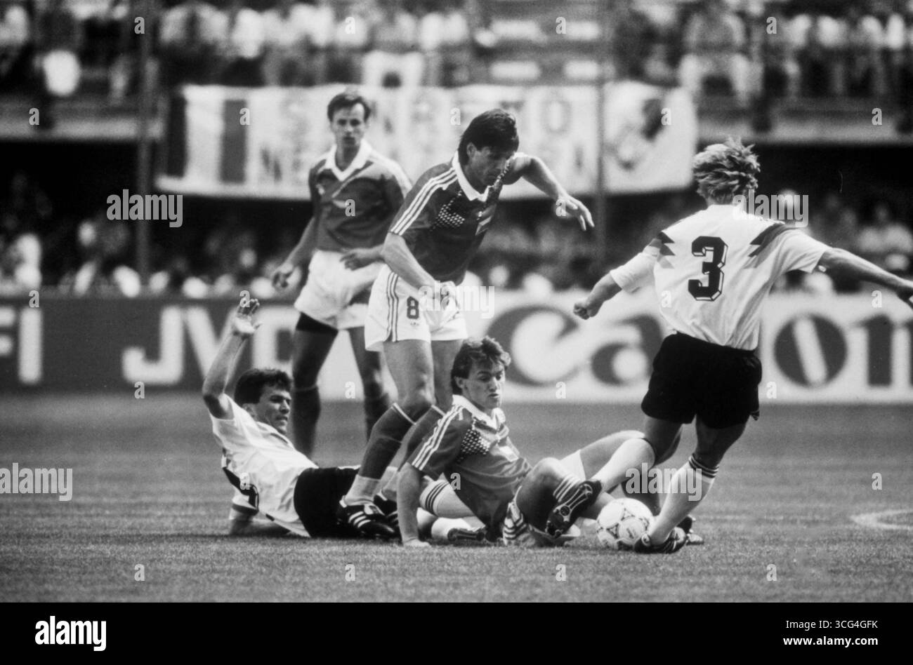 Lothar Matthäus und Andreas Brehme im Zusammenspiel gegen mehrere Spieler der CSFR während des Viertelfinales bei der Fußball-Weltmeisterschaft 1990 in Italien. Stock Photo