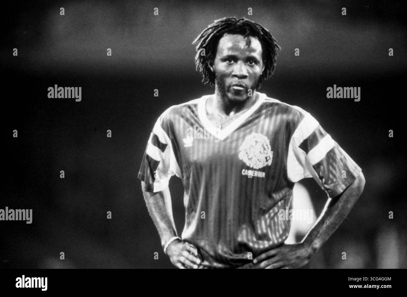 Der kamerunische Mittelfeldspieler Cyrille Makanaky im Viertelfinale der Fußball-WM 1990. Mit entschlossenem Blick und Händen in der Hüfte steht er auf dem Spielfeld. Stock Photo