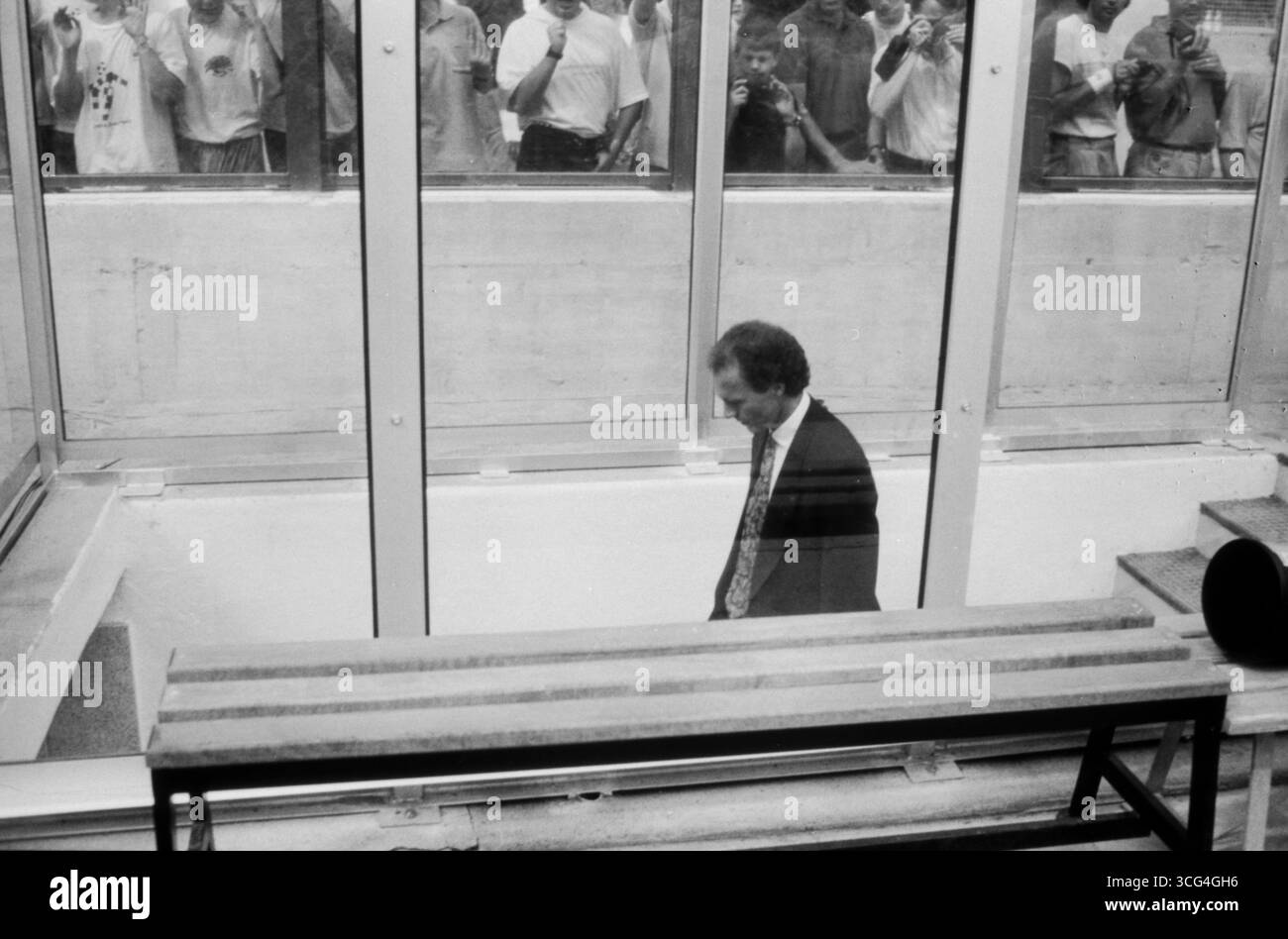Bundestrainer Franz Beckenbauer geht allein und mit gesenktem Blick in die Katakomben des Stadions von Mailand, aufgenommen während des WM-Viertelfinales 1990 gegen die Tschechoslowakeii, beobachtet die Glaswand hinter der Ersatzbank. Stock Photo
