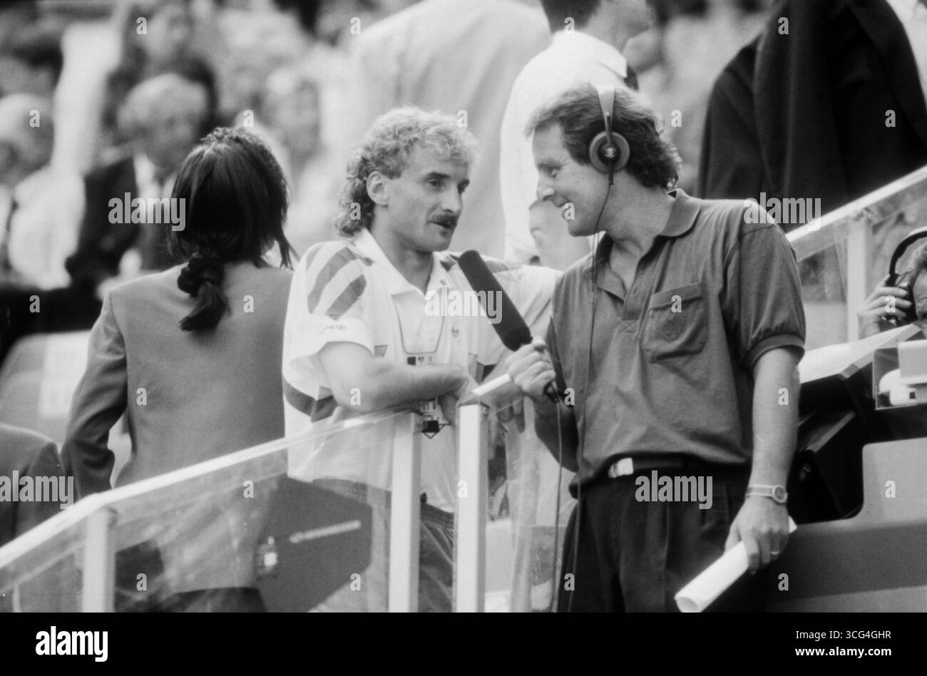 Nationalspieler Rudi Völler gibt vor dem Viertelfinalspiele gegen die Tschechoslowakei ein Interview, in dem er Stellung zu seinem Platzverweis im Achtelfinale gegen die Niederlande - der sogenannten 'Spuck-Affäre' gegen Rijkaard - bezieht. Völler musste deswegen im Viertelfinale auf der Tribüne Platz nehmen. Fernsehjournalist Jörg Wontorra befragt ihn lächelnd mit Headset und Aufnahmegerät. Stock Photo