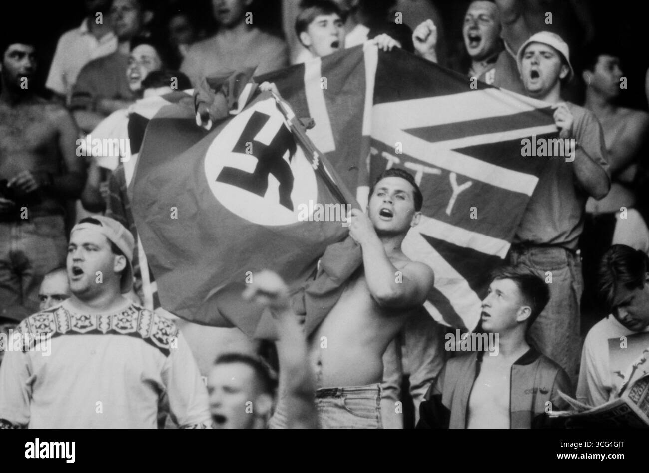 Englische Fans beim Viertelfinale der Fußball-WM 1990 gegen Kamerun. In ihrem Block schwenken einige Anhänger verfassungsfeindliche Fahnen und skandieren lautstark. Stock Photo