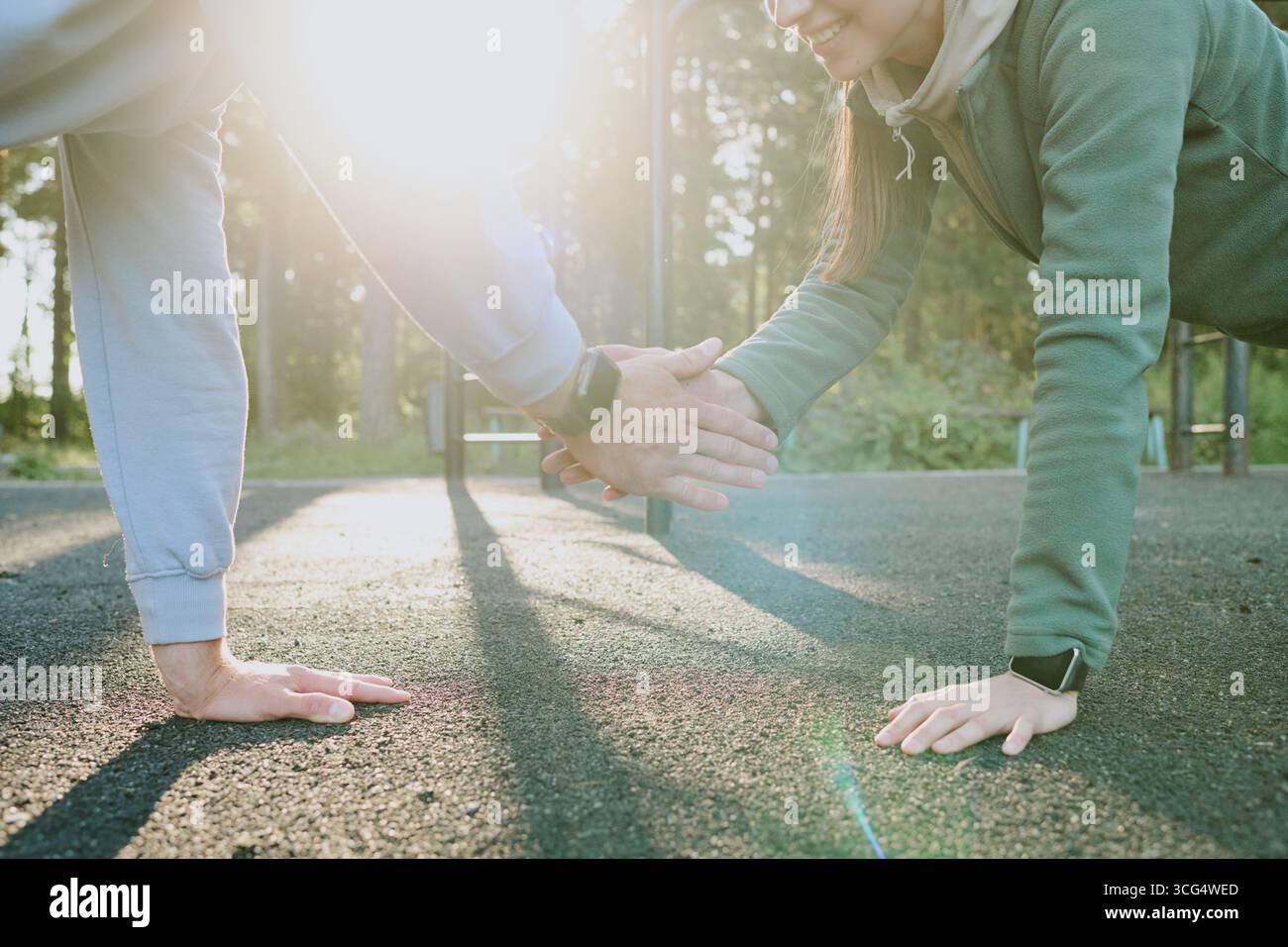Young Adult Caucasian Woman and Man Doing Outdoor Push Ups and Smiling Stock Photo