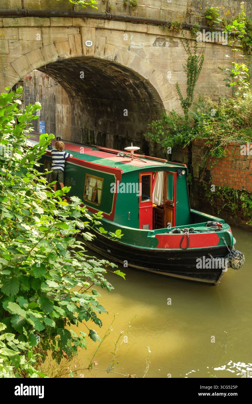 Bradford on Avon, Wiltshire - A narrowboat glides under the bridge besides The Lock Inn on the Kennet and Avon canal near Bradford on Avon in Wiltshir Stock Photo