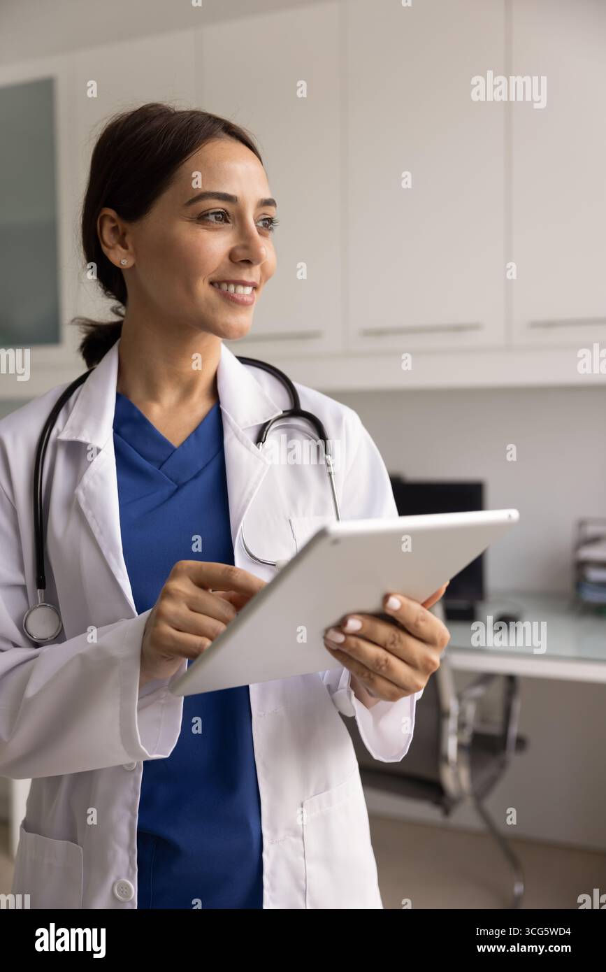 Happy young Middle Eastern physician woman using digital tablet Stock Photo