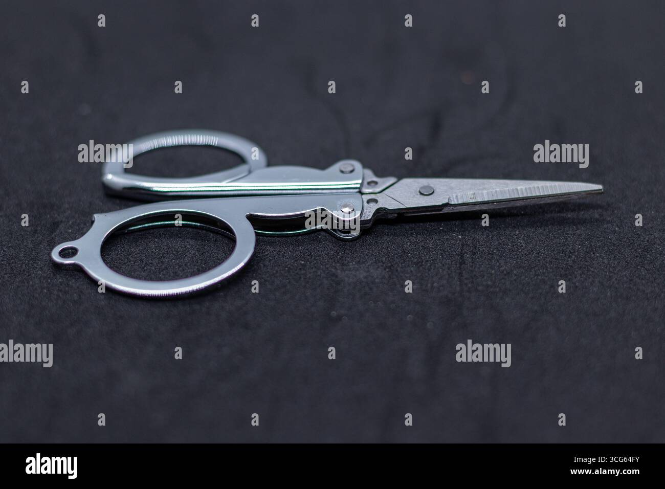 Close-up of children’s craft scissors featuring bright yellow plastic handles and pointed stainless steel blades. Safe. Stock Photo