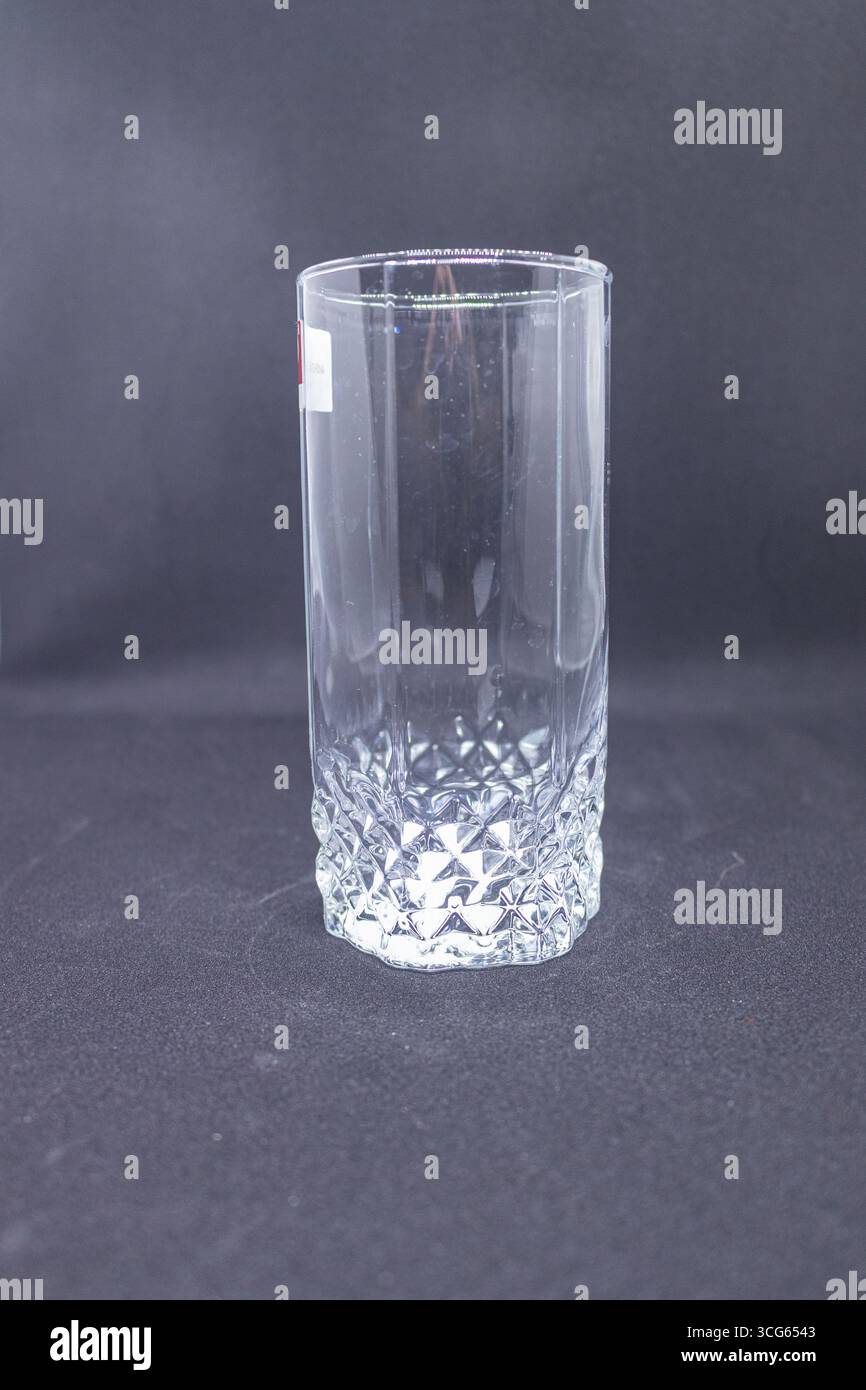 Close-up of a clear glass featuring a textured diamond-shaped base. Elegant drinkware design with intricate patterning, perfect for beverages. Stock Photo