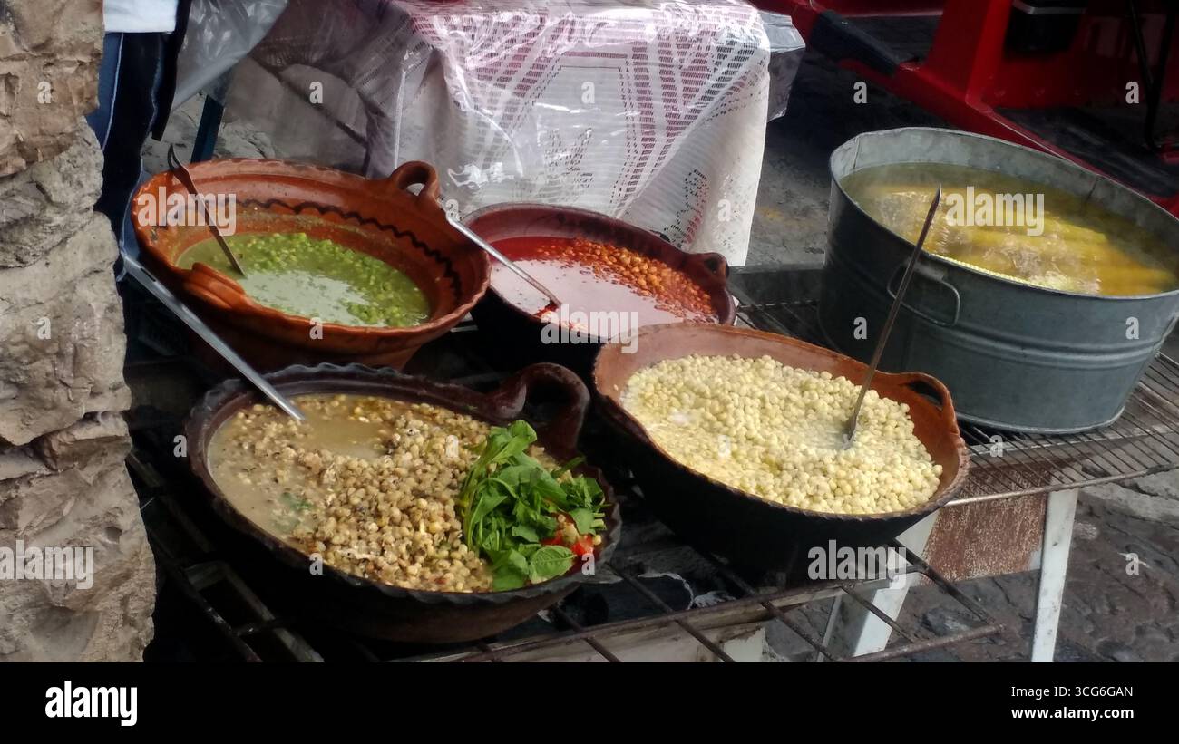 Corn kernels cooked with epazote of various flavors in clay pots. Esquites typical Mexican dish prepared with cream, cheese, chili powder and lemon Stock Photo