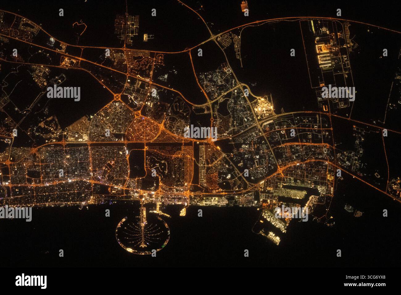 The city lights of Dubai Palm Jumeirah, the palm tree-shaped artificial island, is a highlight in the United Arab Emirates' city of Dubai in this nighttime photograph from the International Space Station as it orbited 258 miles above the Persian Gulf. Aug. 26, 2023  An optimised version of an original NASA image: Credit NASA/ SAlneyadi Stock Photo