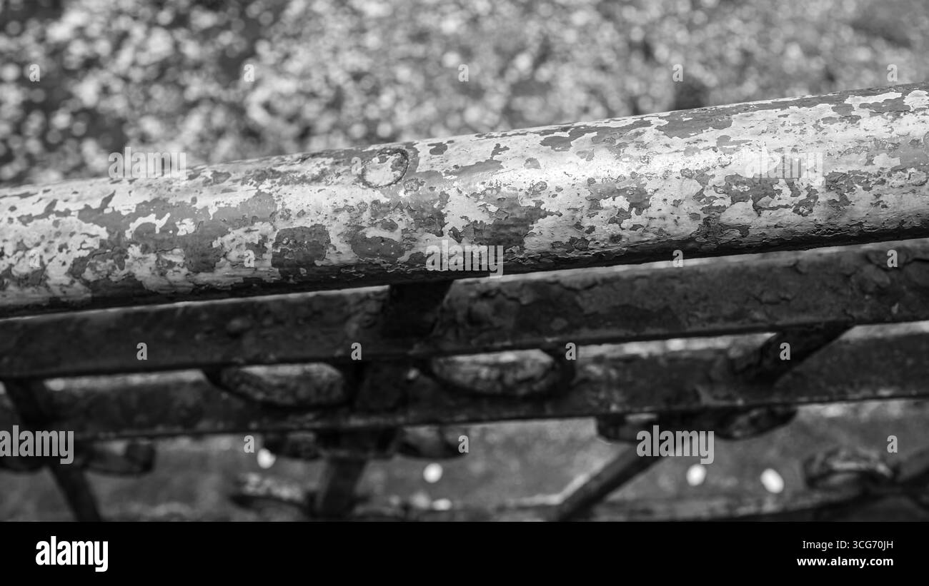Monochrome photograph of a weathered and peeling rustic metal railing ...