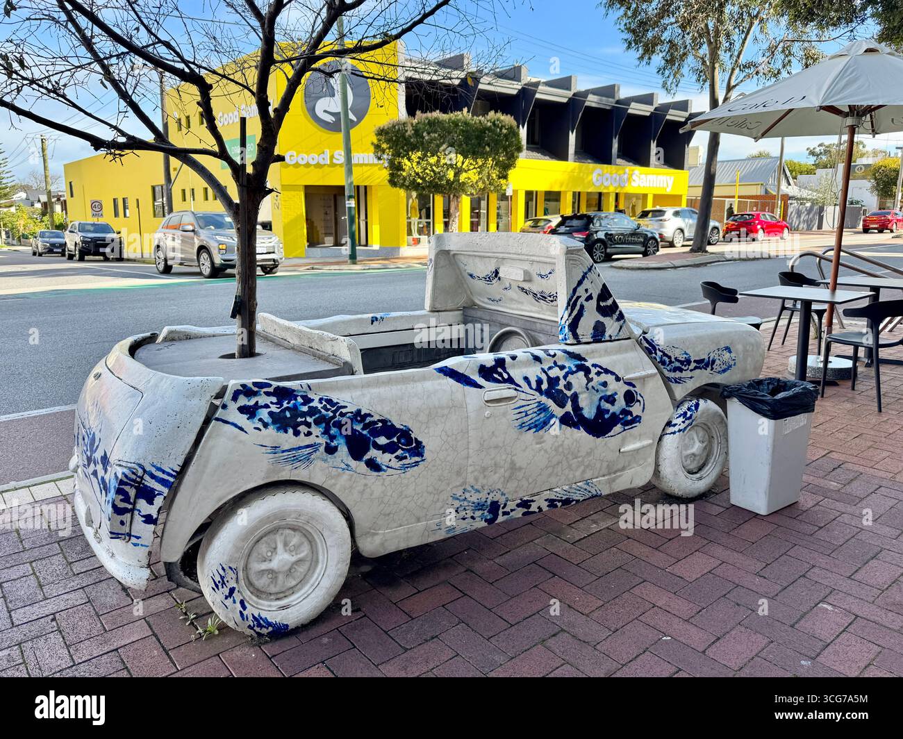 Public art car Aston Mini sculpture by Artitecture with a tree growing through it located on Oxford Street Leederville Perth Western Australia - Smartphone Captured Stock Image