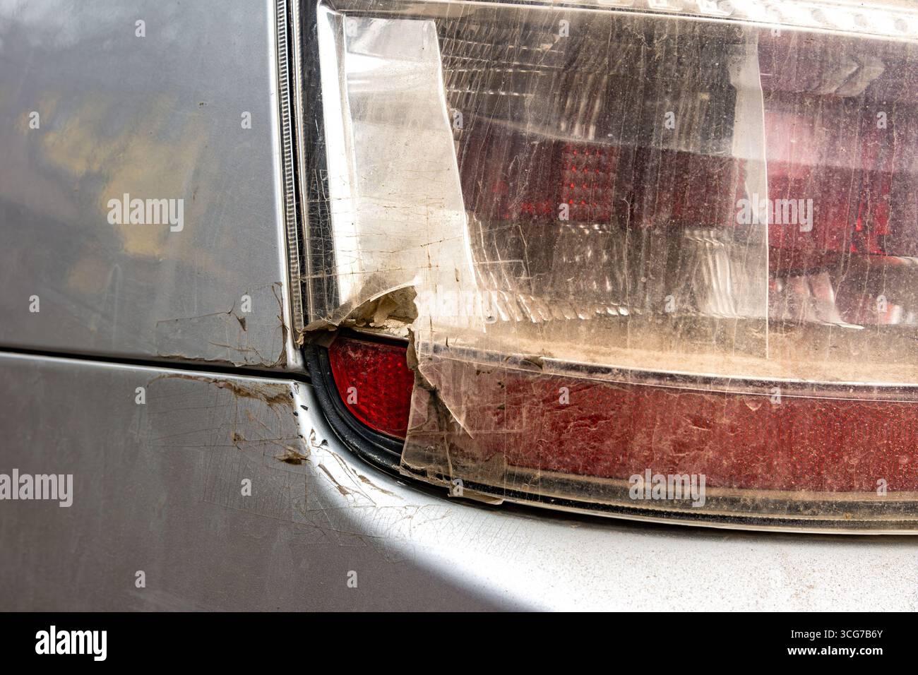 A close-up of a severely damaged tail light with torn plastic cover and exposed internal components, indicating impact damage or long-term neglect wit Stock Photo