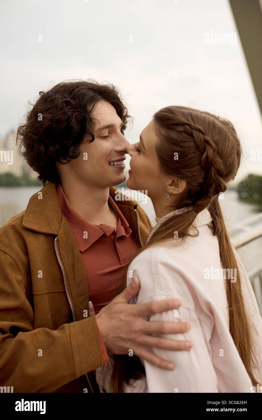 A loving couple enjoys a blissful walk together, sharing intimate smiles beside a river. Stock Photo