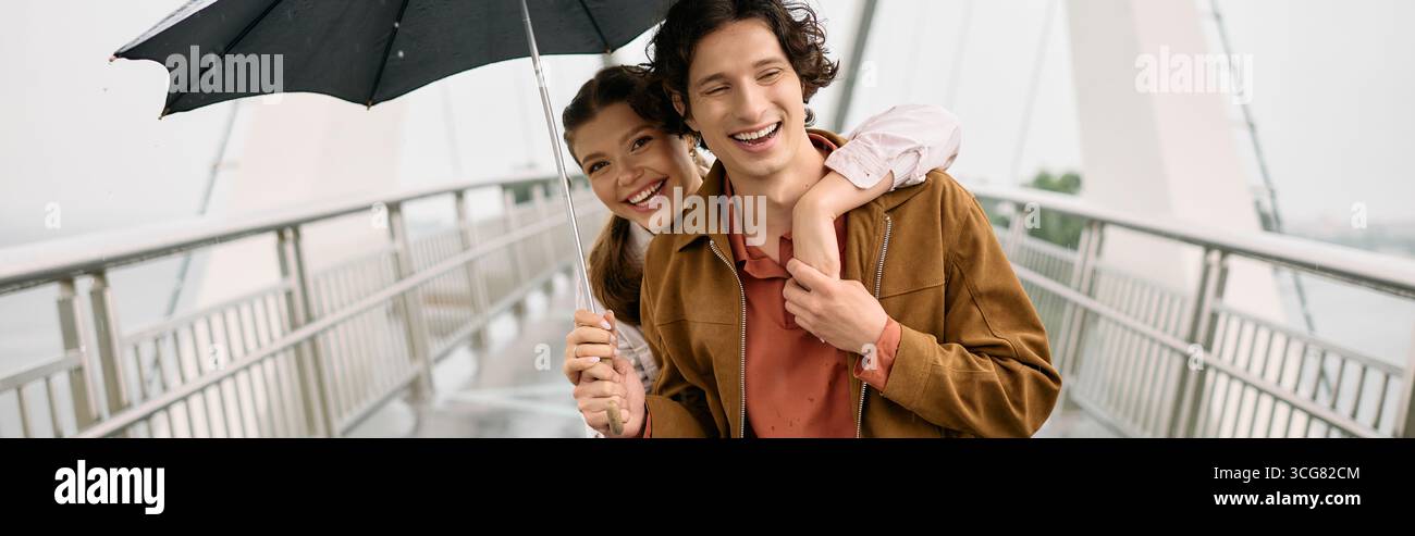 Loving young couple shares laughter while taking a leisurely stroll on a rainy day in the park. Stock Photo