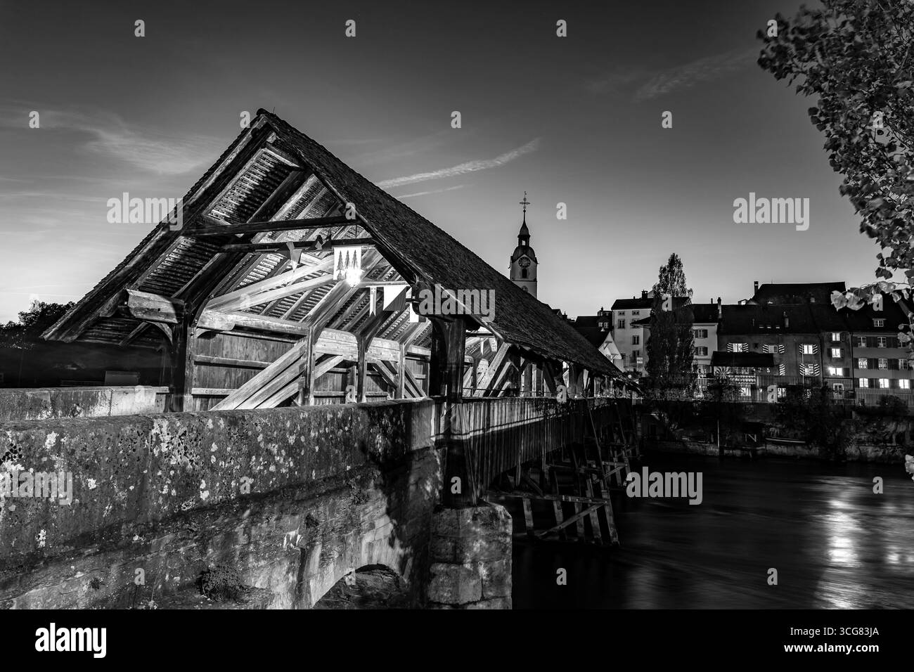 Old Town and the Historical Covered Wood Bridge Holzbr³cke with Flags over River Aare in Dawn in Olten, canton Solothurn, Switzerland. Stock Photo