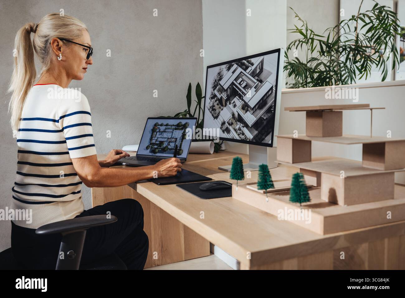 Female architect analyzing building designs on a computer screen and ...