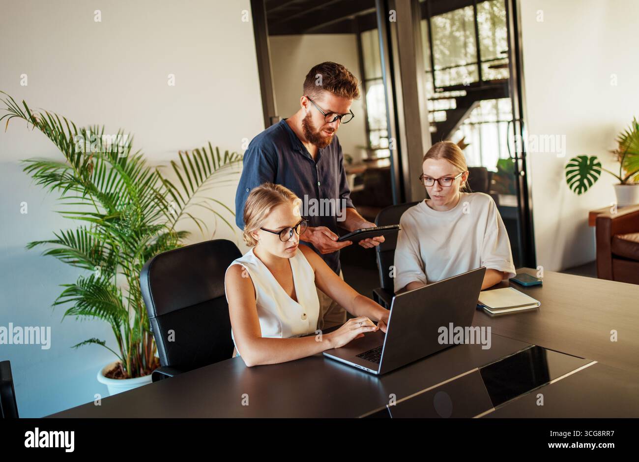 Engaging in a Collaborative Work Session within a Contemporary Modern Office Space Setting Stock Photo