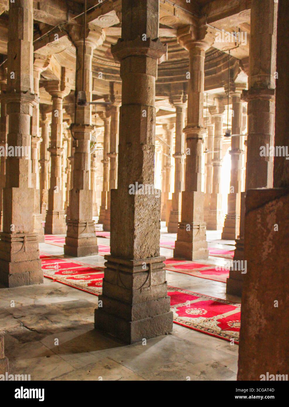 The Jama Masjid in Ahmedabad, built in 1424, is a stunning example of Indo-Islamic architecture. Constructed with yellow sandstone, the mosque features a large central courtyard, intricately carved pillars, and multiple domes. The facade is adorned with ornate arches and latticework windows, blending Hindu and Islamic design elements. Stock Photo