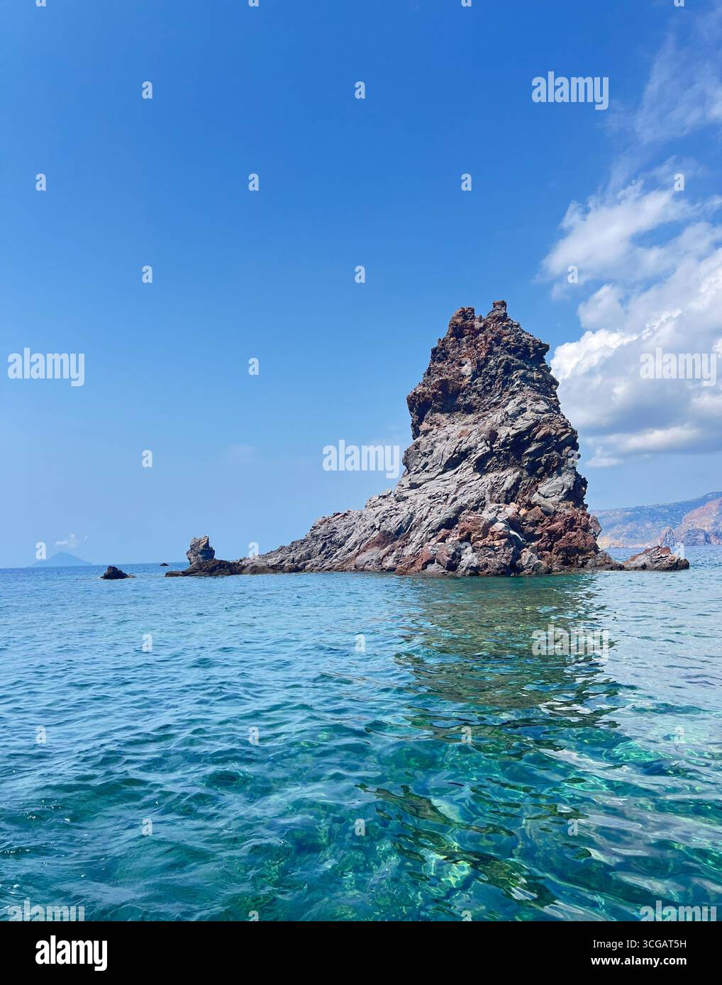 The Faraglione rock formation on Vulcano Island, Aeolian islands, Sicily, Italy, with reflection in crystal-clear water. - Smartphone Captured Stock Image