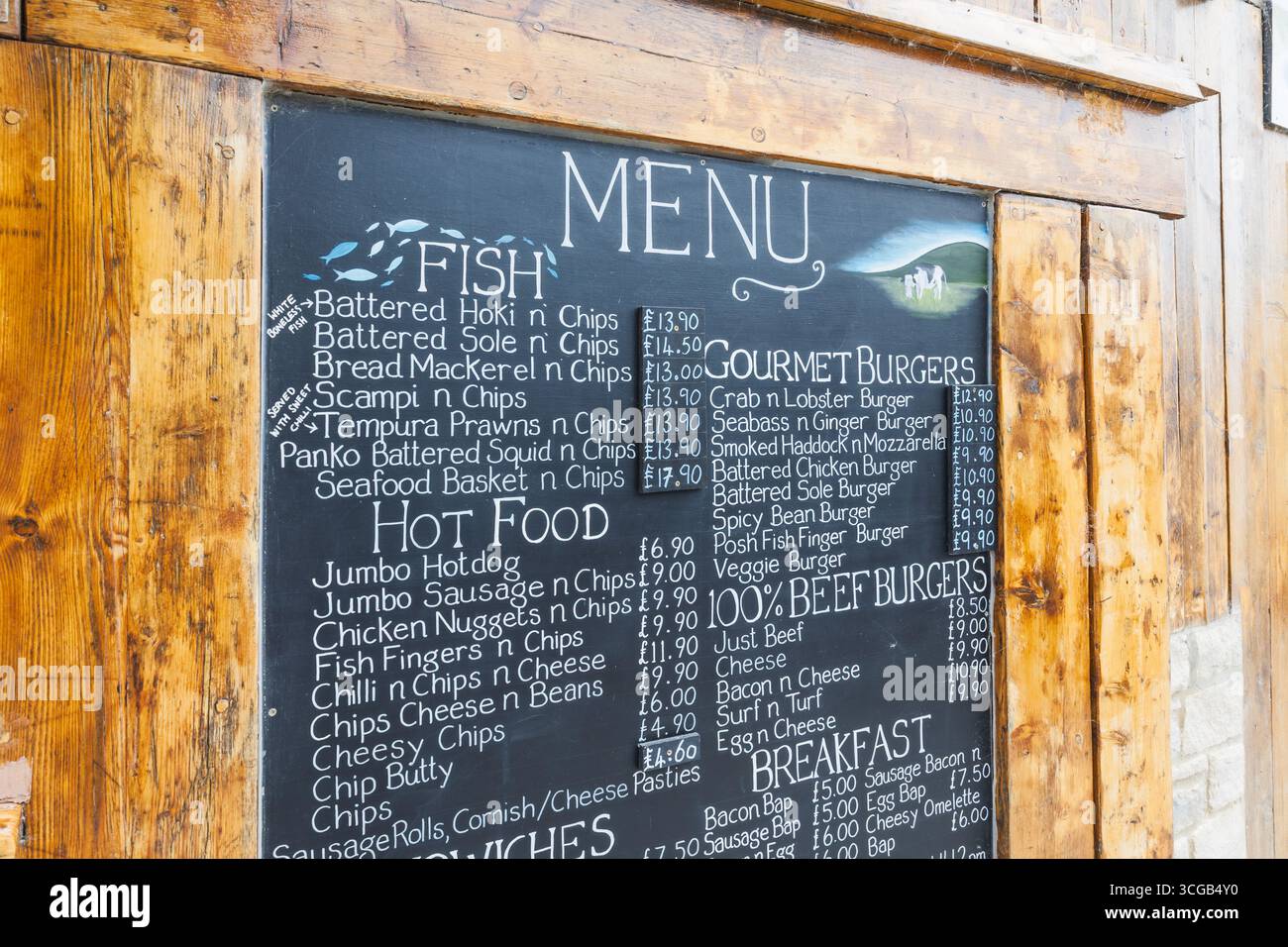 Rustic chalkboard cafe menu with handwritten specials on wooden frame outside restaurant Stock Photo