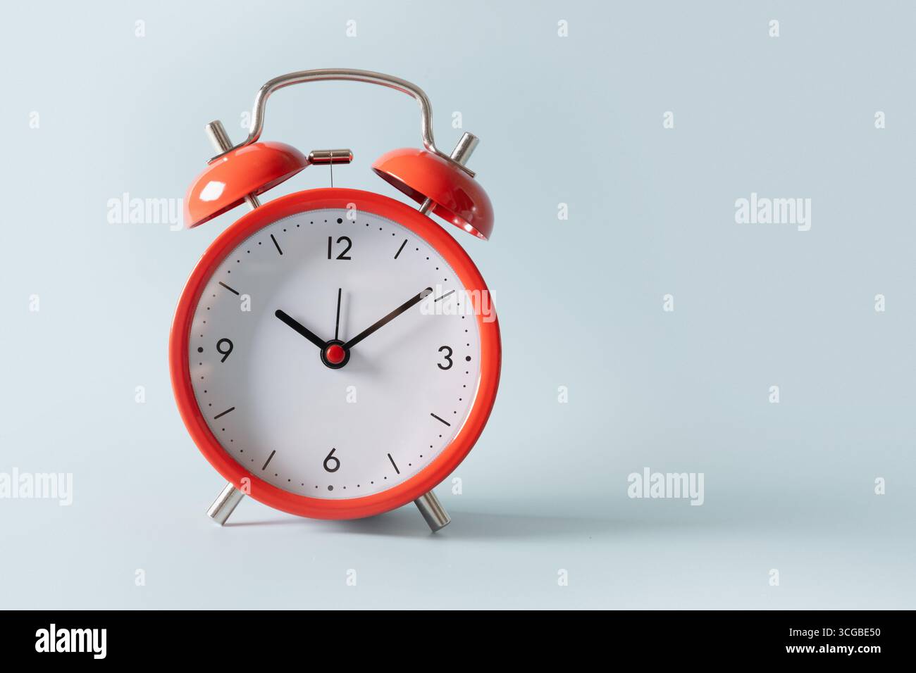 Red alarm clock on blue background. Close up. Stock Photo