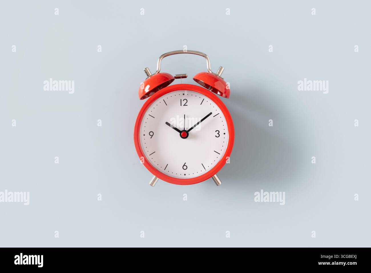 Red alarm clock on blue background. View from above. Stock Photo
