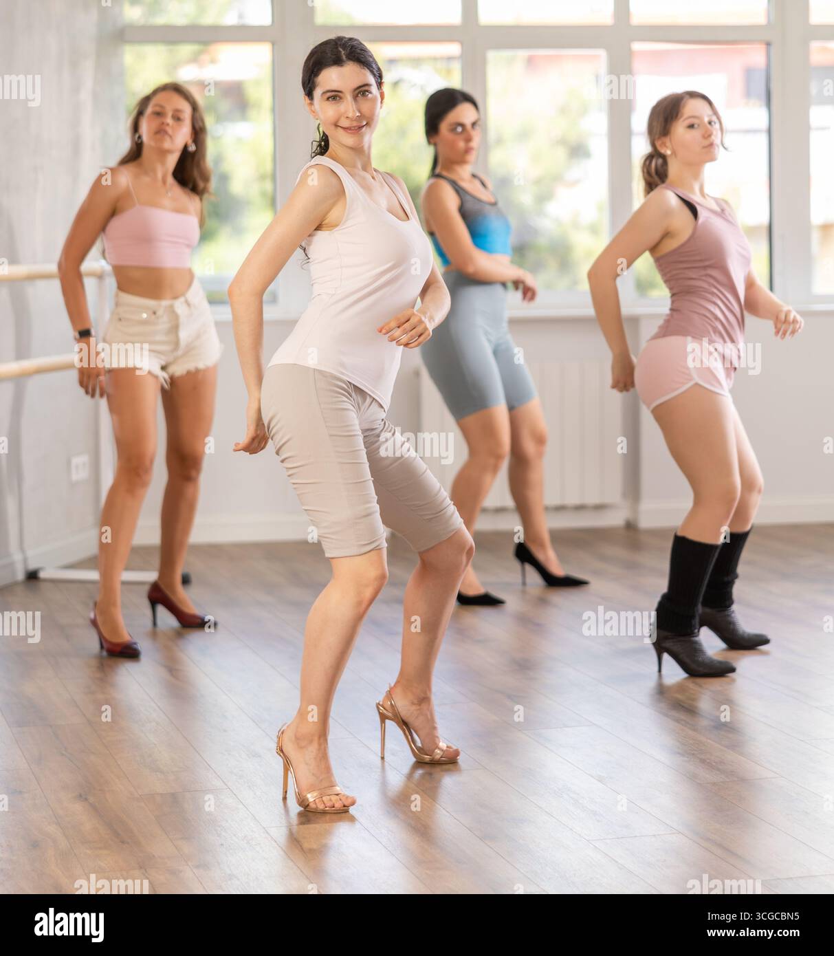 Slim brunette in heels practicing jazz-funk dance in studio Stock Photo