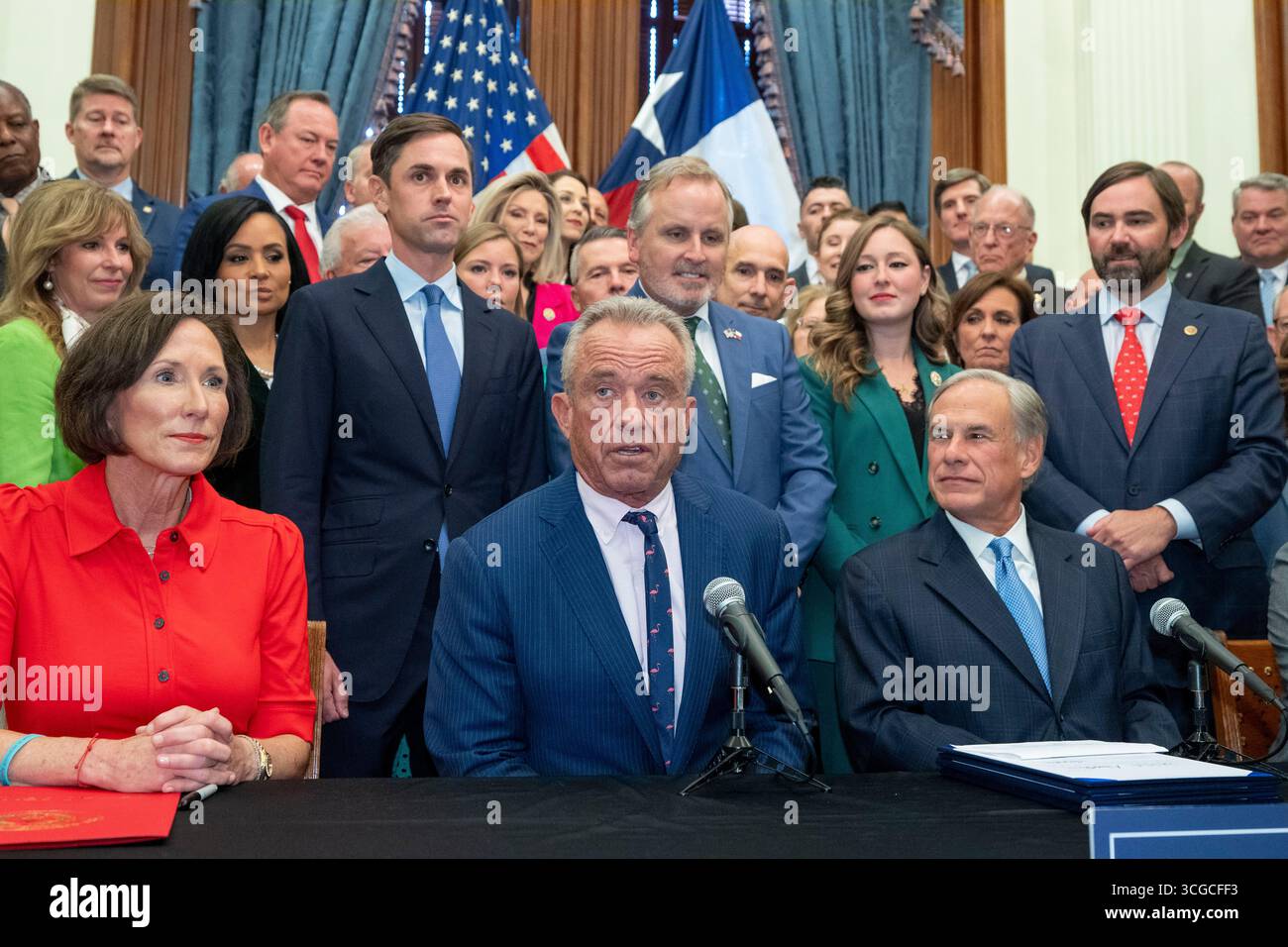Austin, United States. 27th Aug, 2025. U.S. Secretary of Health & Human Services ROBERT F. KENNEDY, JR.(c) speaks to the press at the Texas Capitol as Governor GREG ABBOTT (r) finishes signing three Health-related bills regulating additives, forbidding welfare benefits to pay for sugary snacks and other health measures on August 27, 2025. At left is Sen. LOIS KOLKHORST, R-Brenham. Credit: Bob Daemmrich/Alamy Live News Stock Photo