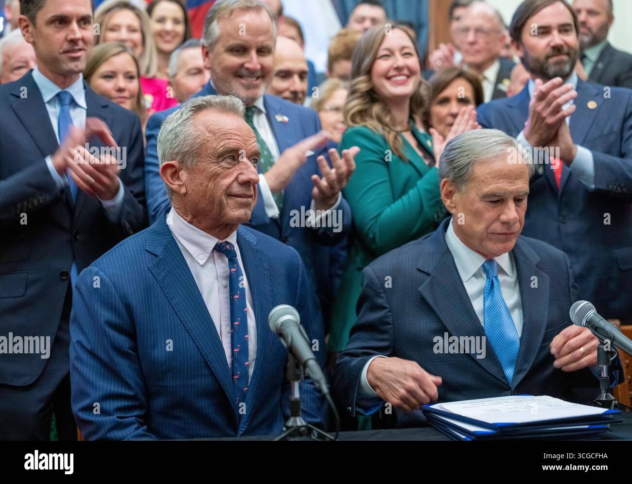 Austin, United States. 27th Aug, 2025. U.S. Secretary of Health & Human Services ROBERT F. KENNEDY, JR. (l) speaks to the press at the Texas Capitol as Governor GREG ABBOTT finishes signing three Health-related bills regulating additives, forbidding welfare benefits to pay for sugary snacks and other health measures on August 27, 2025. Credit: Bob Daemmrich/Alamy Live News Stock Photo