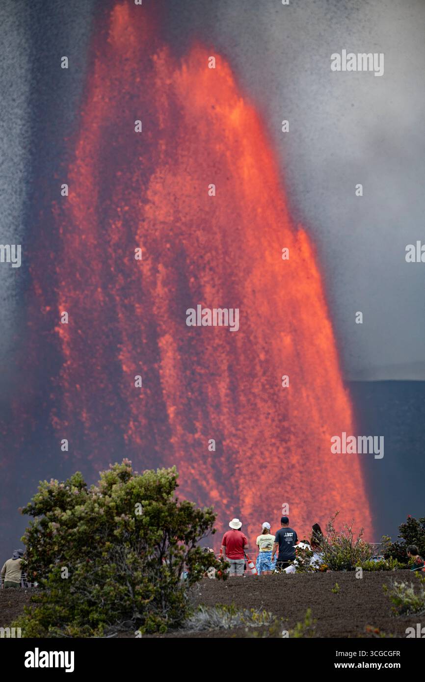 visitors gather at an overlook to view fountains of hot lava shooting up 1000 feet from Halemaumau Crater, Kilauea Volcano, HVNP, Hawaii Island, USA Stock Photo