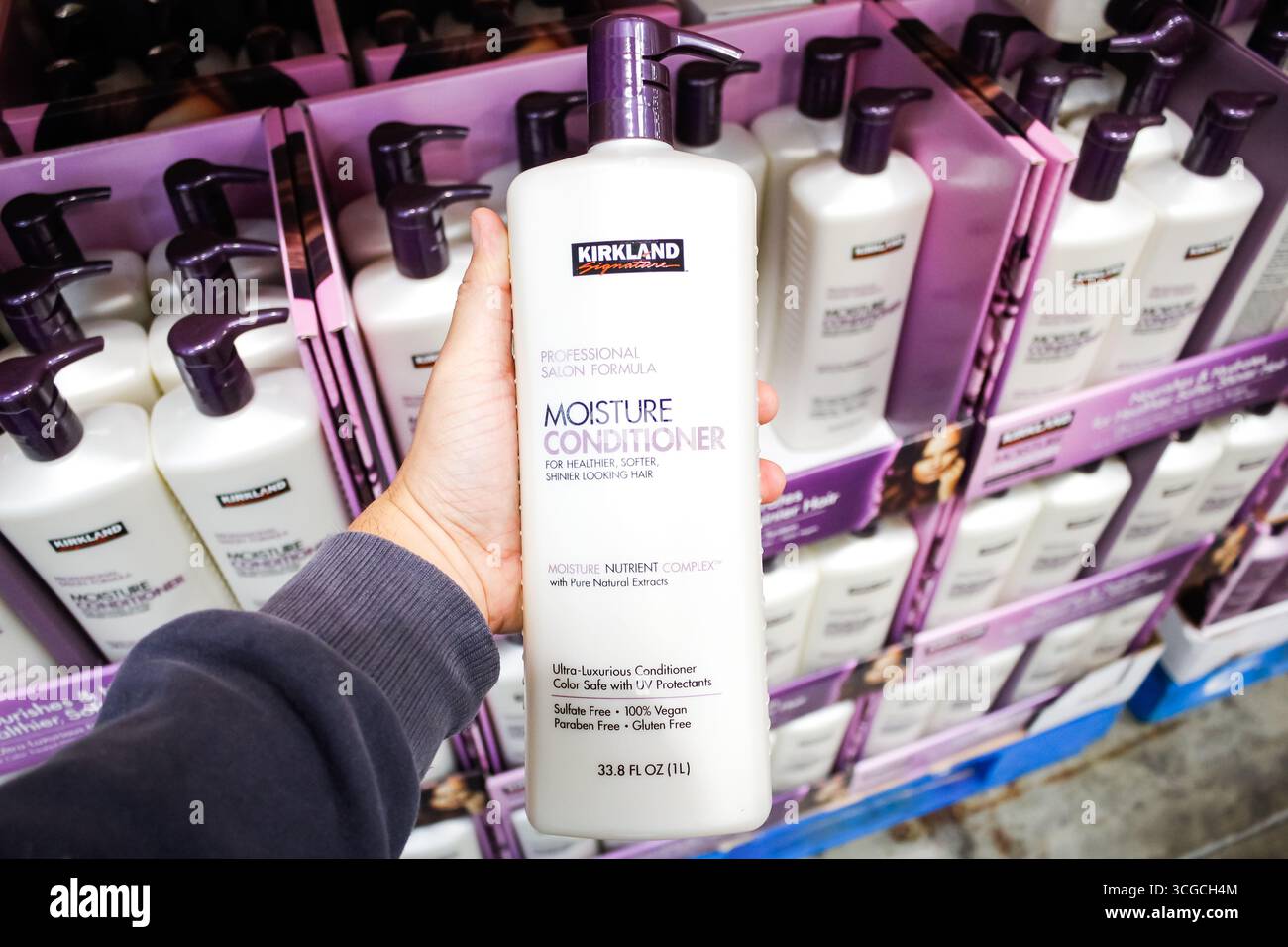 Los Angeles, California, United States - 02-13-2020: A hand holds a bottle of Kirkland Signature Moisture Conditioner on display at a local Costco. Stock Photo