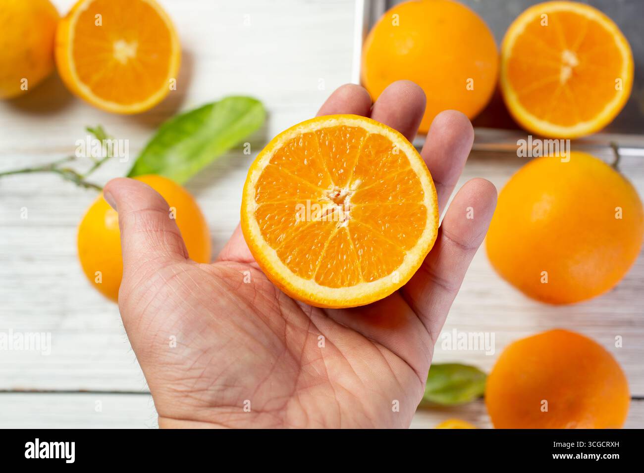 Hand holding half orange hi-res stock photography and images - Alamy