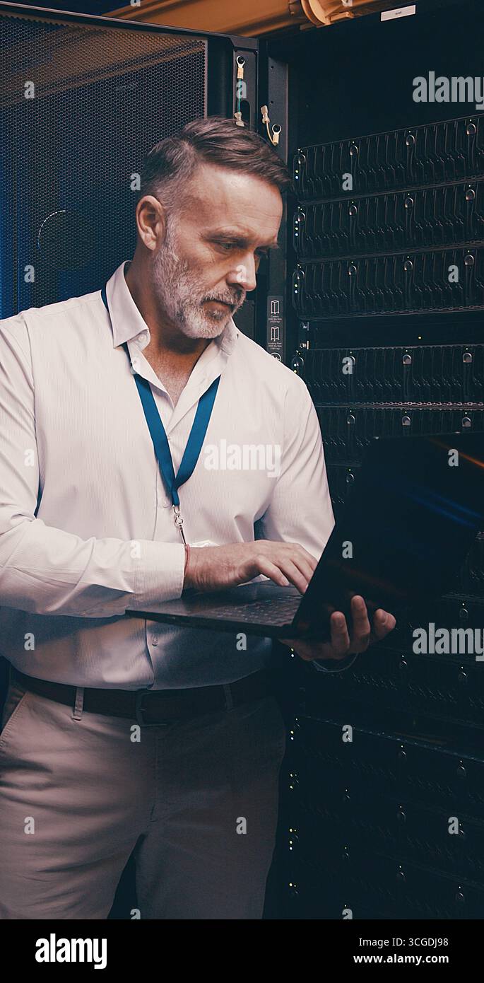 Laptop, typing and technician or man in server room for cyber security, software update and database system. Programmer, developer and cybersecurity Stock Photo