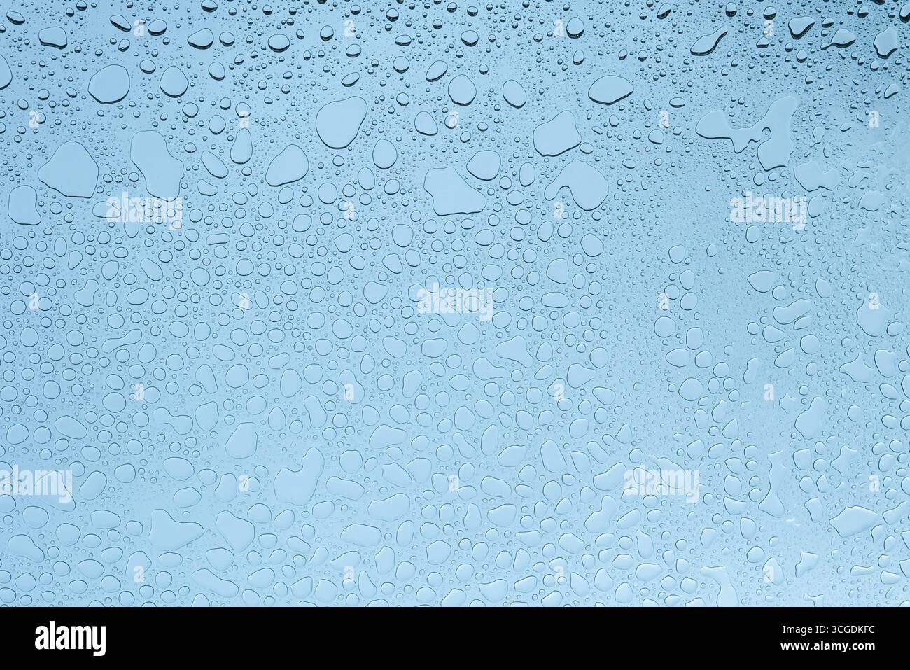 Water drops on glass in blue color temperature Stock Photo