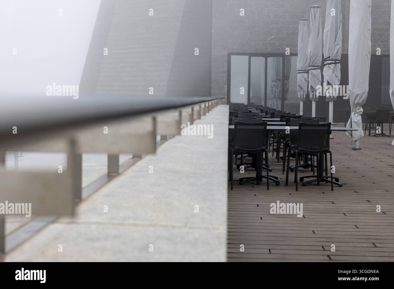Modern Restaurant Terrace with Railing in the Clouds in a Cloudy Day in Monte Generoso, Ticino, Switzerland Stock Photo