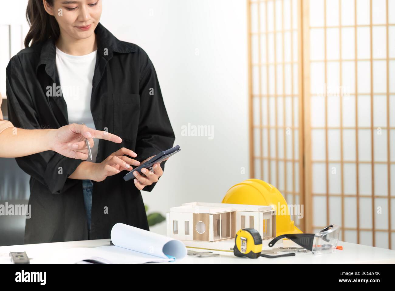 Digital Planning. Architect using smartphone to discuss construction project details. Stock Photo
