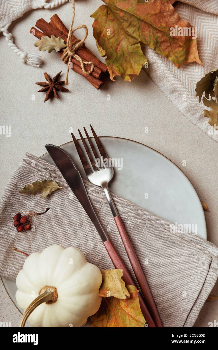 Minimal thanksgiving table setting with fork and pumpkin.. Stock Photo
