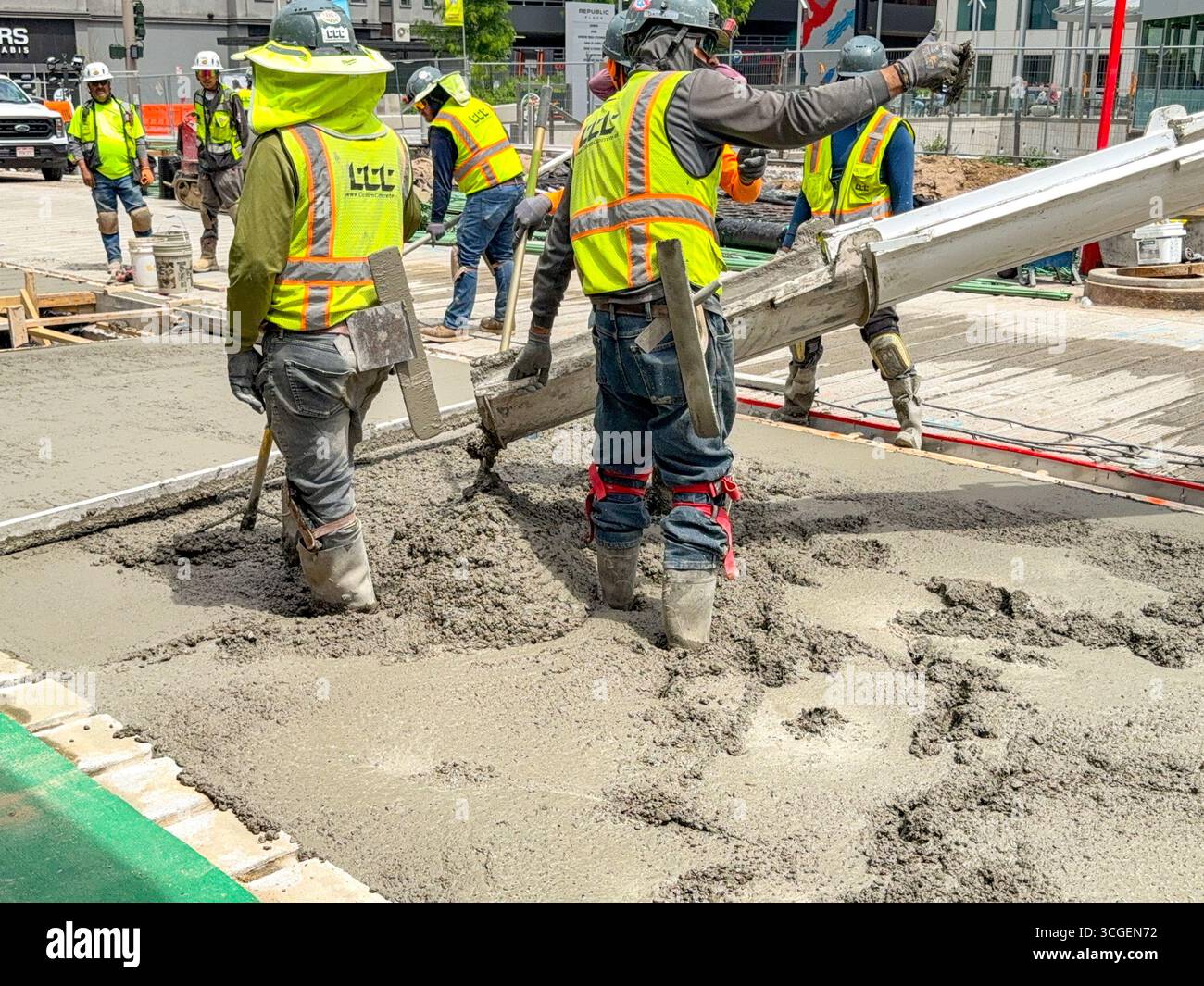 Denver, Colorado, USA - 4 June 2025: Construction workers laying concrete on a new roadway in downtown Denver - Smartphone Captured Stock Image