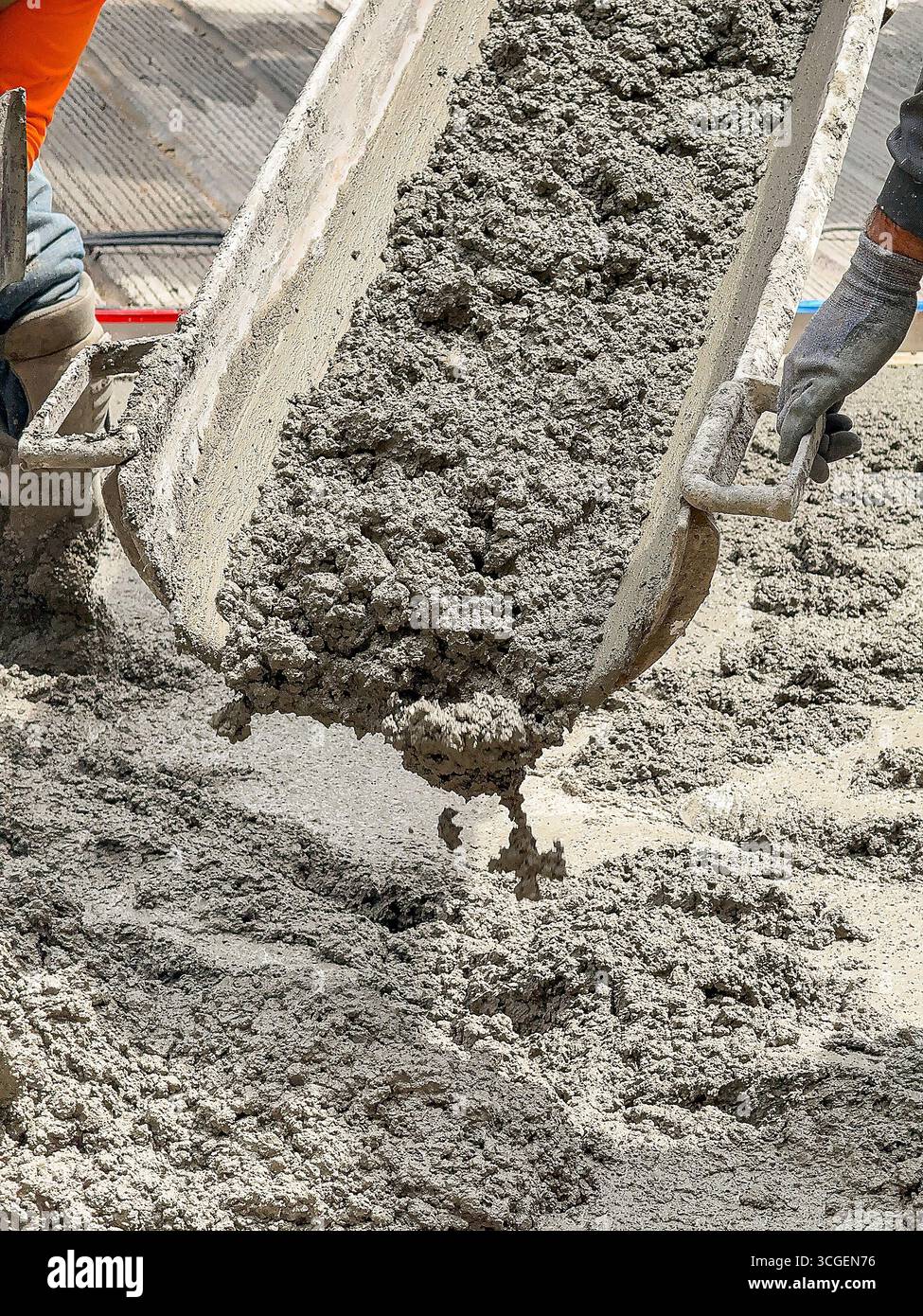 Fresh wet concrete being poured onto the foundation for a road in a city street. - Smartphone Captured Stock Image