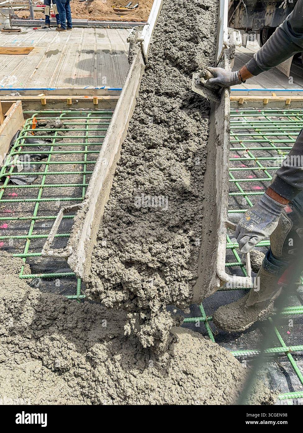 Denver, Colorado, USA - 4 June 2025: Fresh wet concrete being poured onto the reinforced foundation for a road in a city street. - Smartphone Captured Stock Image